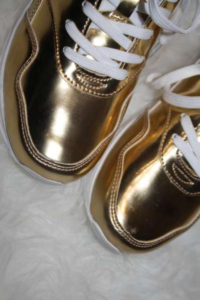 Стильні золотисті кросівки в фото 4